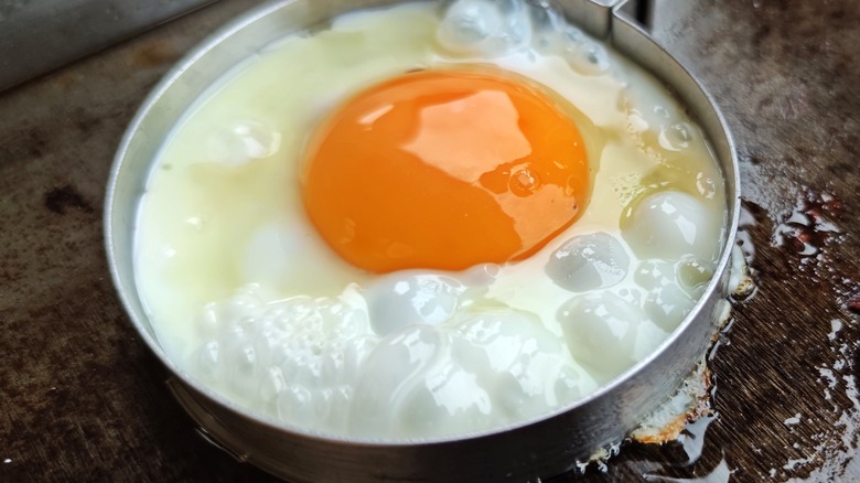 egg cooking in round jar lid