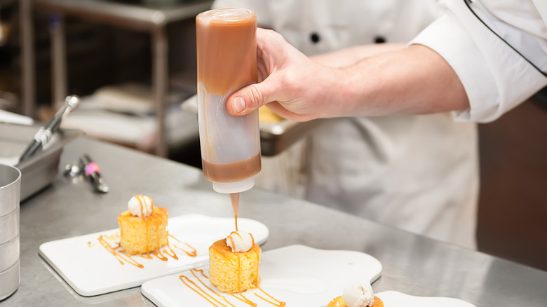 chef squeezes caramel from bottle