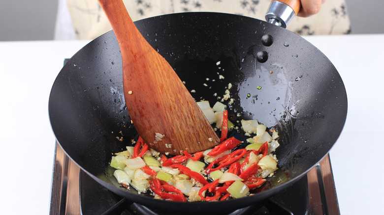 cooking chilis and onions in wok