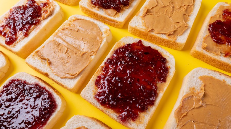 Three diagonal rows of sliced bread, half with peanut butter and the other half with jelly