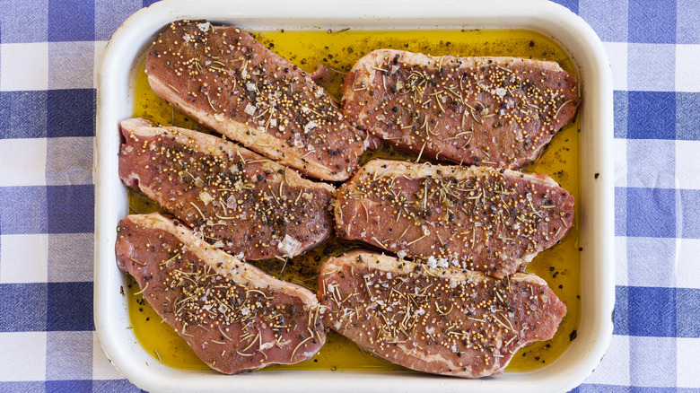 seasoned steak marinating in oil