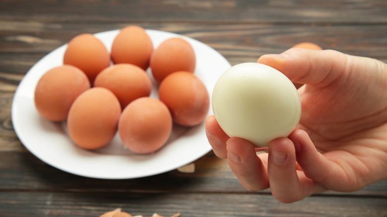 Hand holding peeled egg