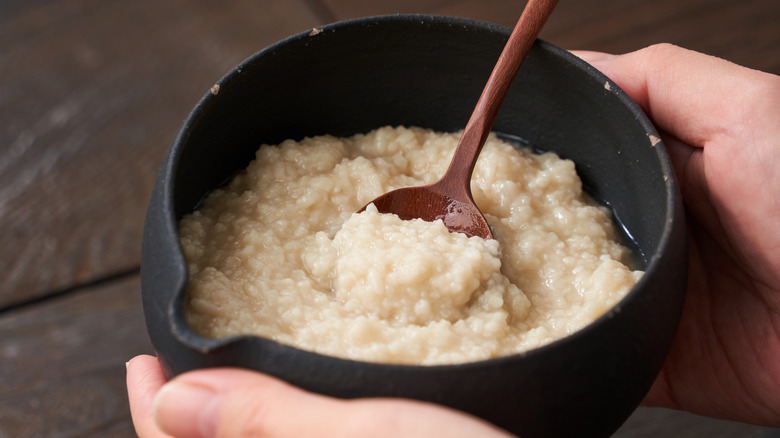 Two hands holding a bowl of Shio Koji