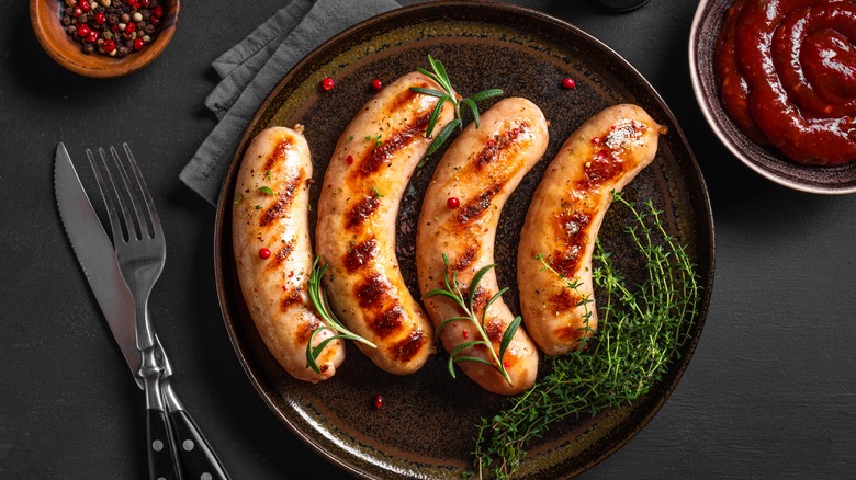 Roasted German sausages with herbs and spices on plate