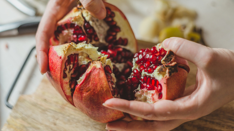 Person opening a pomegranate