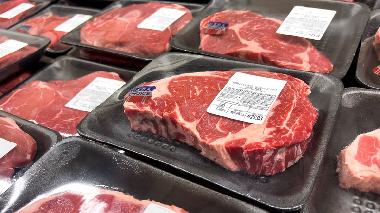 A stack of packaged ribeye steaks.