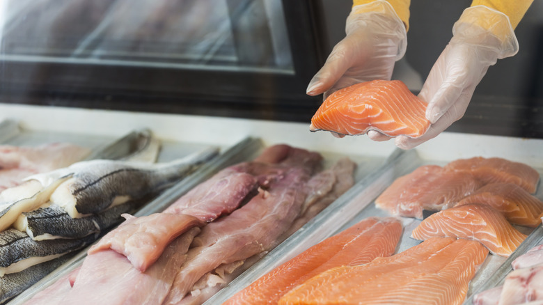 Person holding fillet of salmon at store