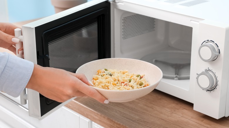 Person putting food in a microwave