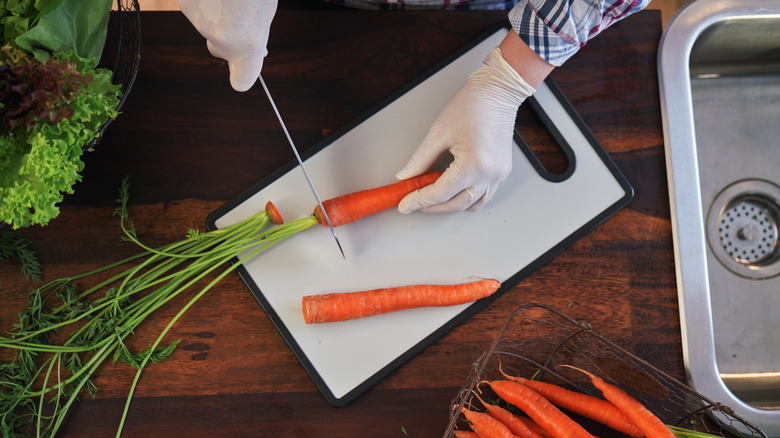 Cutting carrots on a plastic cutting board