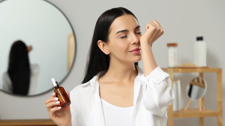 Woman smelling perfume on her wrist