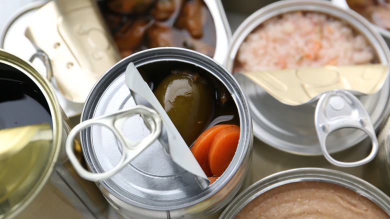 Cans of vegetables and meat are opened and viewed from above