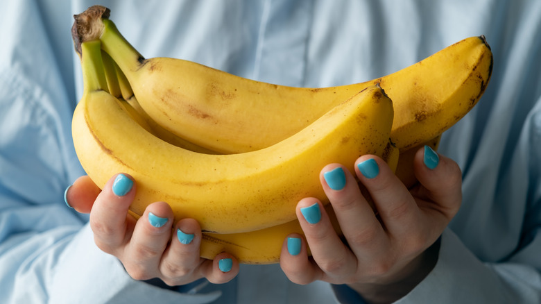 Hands holding yellow bananas