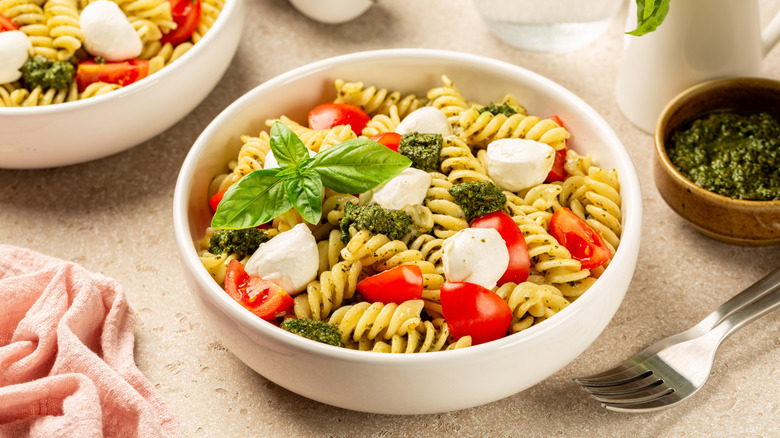 Two bowls with cold pasta salad with homemade pesto sauce