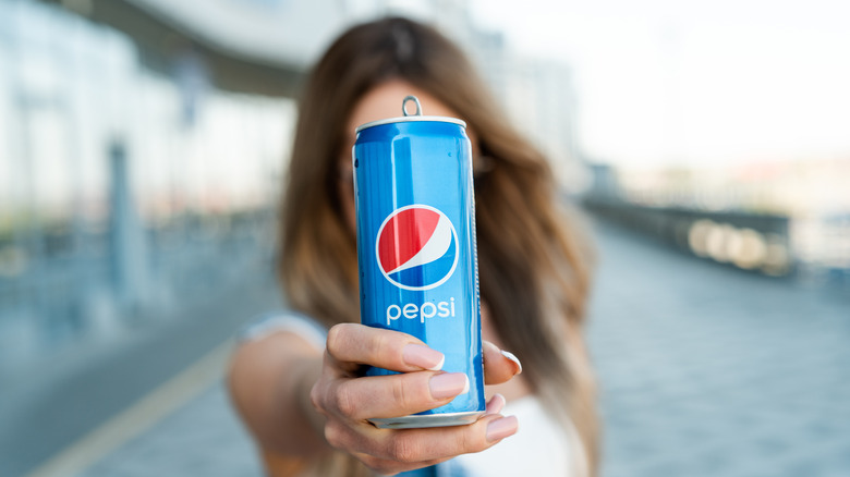 Holding slim pepsi soda can 