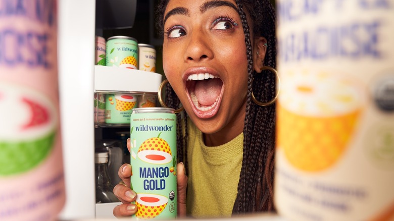 Person taking wildwonder Mango Cold can from fridge