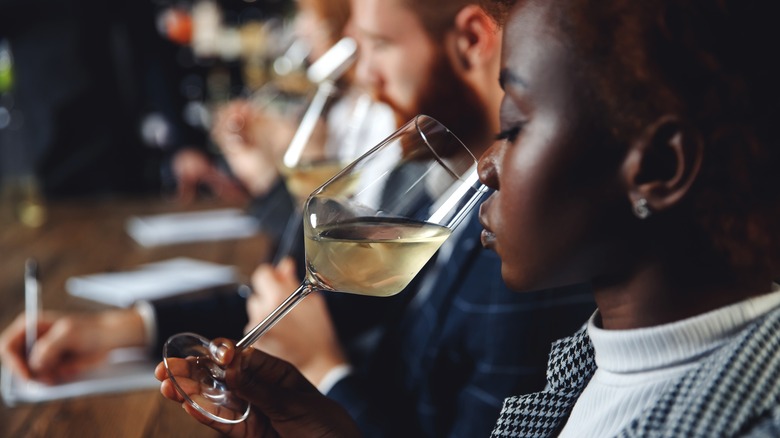 Woman sniffing white wine glass