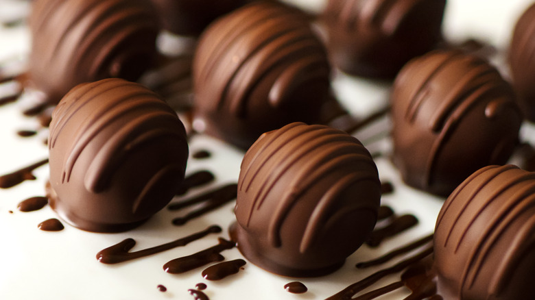 Chocolate covered bourbon balls with a chocolate drizzle