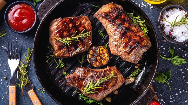 Seared steak in pan with herbs