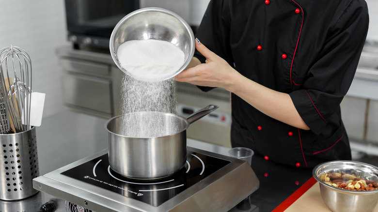 Person making sugar syrup on stove top