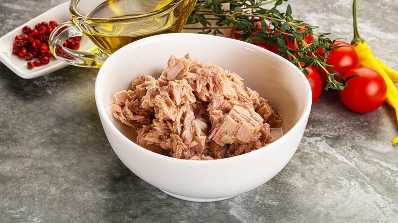 tuna in a white bowl surrounded by ingredients