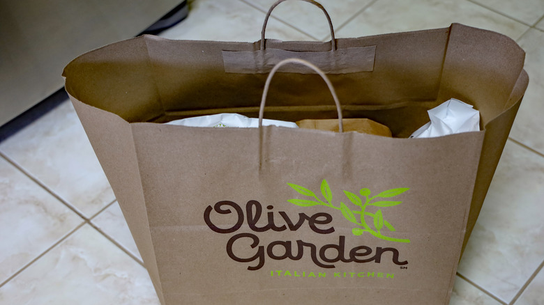 Paper Olive Garden takeout bag sitting on tile floor