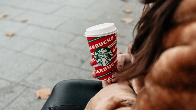 Woman holding holiday Starbucks cup