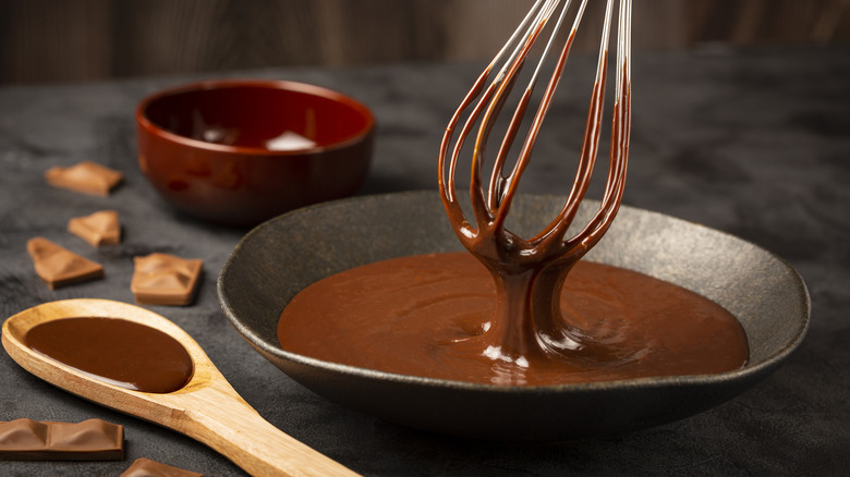 Chocolate ganache dripping from metal whisk