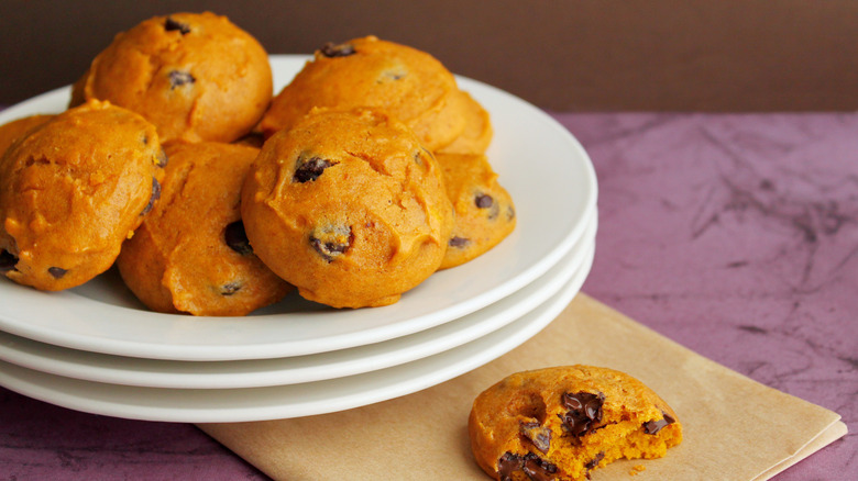 Plate of soft pumpkin chocolate chip cookies with one half eaten