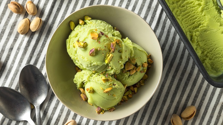 Pistachio ice cream in a bowl with crushed pistachios on top