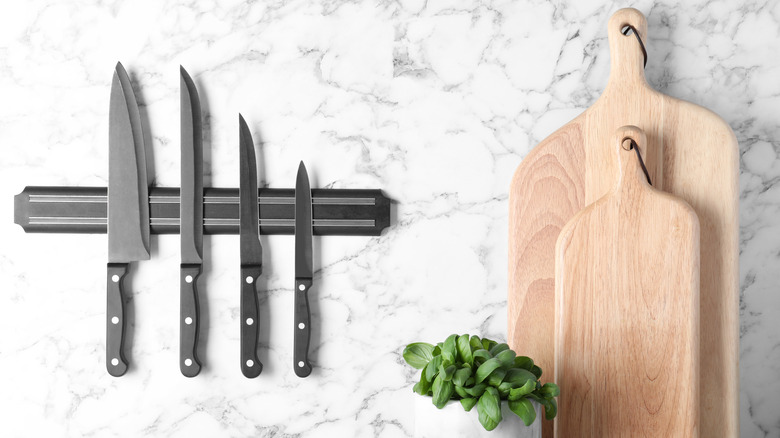 Knives mounted on wall with cutting boards