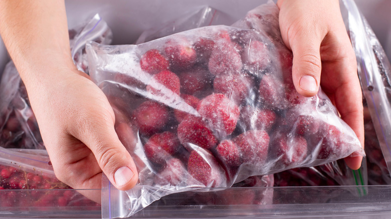 Person holding bags of frozen fruit