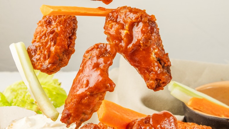 Tossed chicken wings with celery and carrot sticks