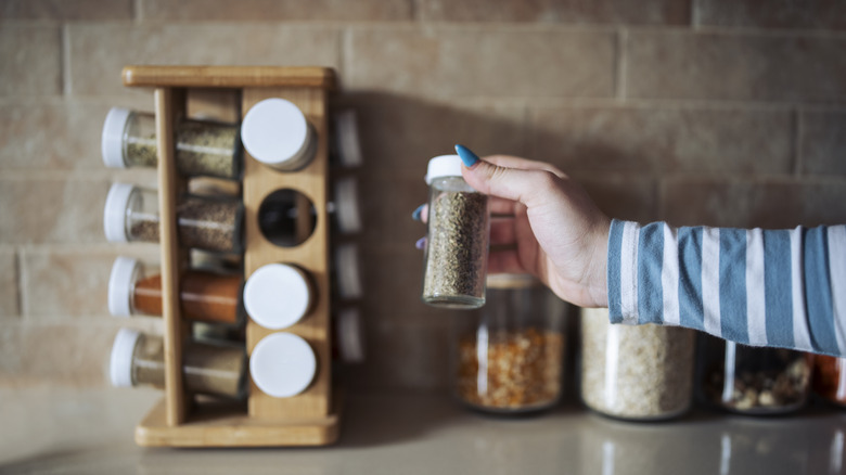 Arm reaching for jar from spice rack