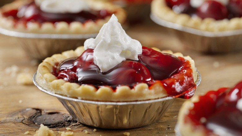 Mini cherry pies topped with whipped cream