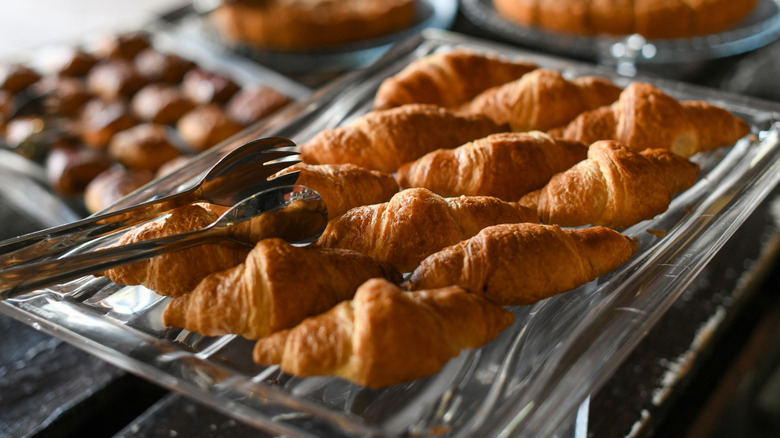 tongs with plate of croissants