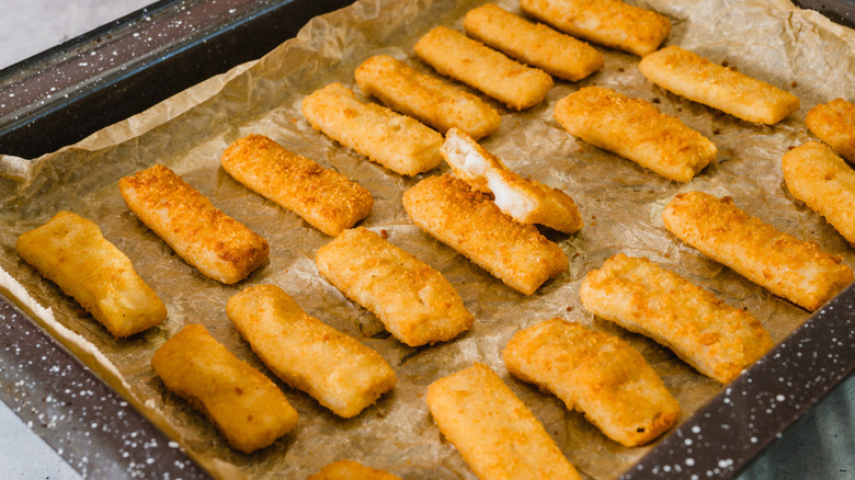 Crispy fish sticks on a parchment paper-lined pan