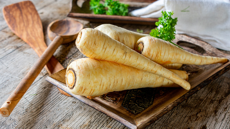 Parsnips on table with wooden spoon