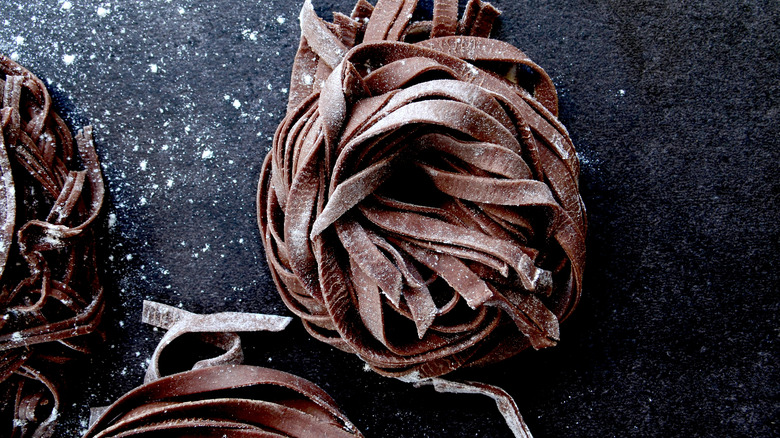 A nest of fresh egg pasta noodles made with cocoa powder