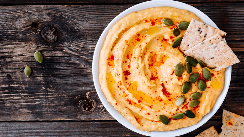 pumpkin hummus in a bowl with pepitas