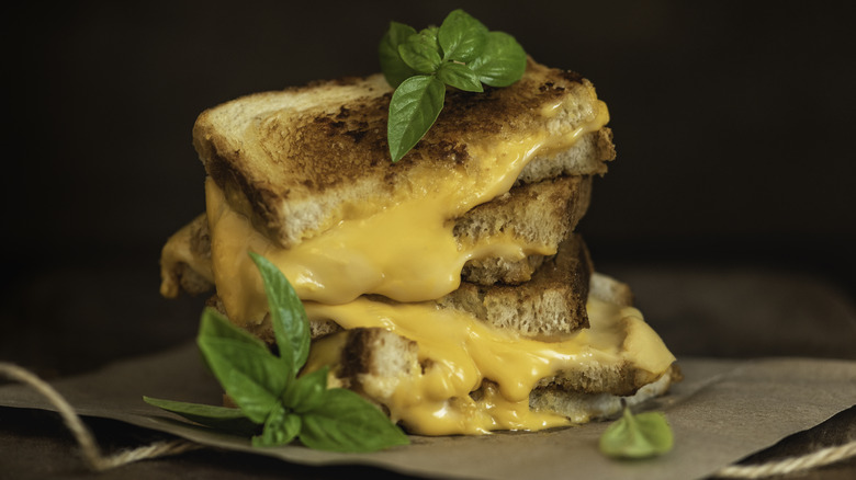 grilled cheese halves stacked with sprigs of herbs
