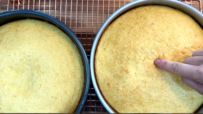 Finger touching cooked yellow cakes