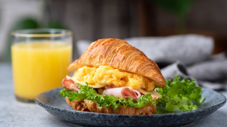 Soft scrambled eggs on ham croissant sandwich