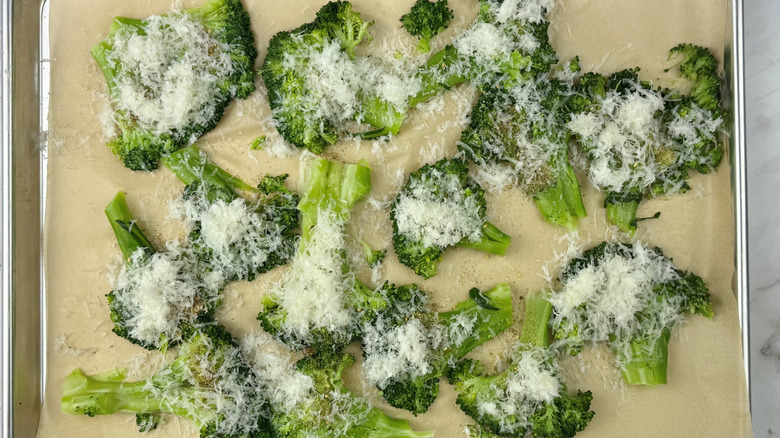 grated parmesan sprinkled over broccoli on baking sheet