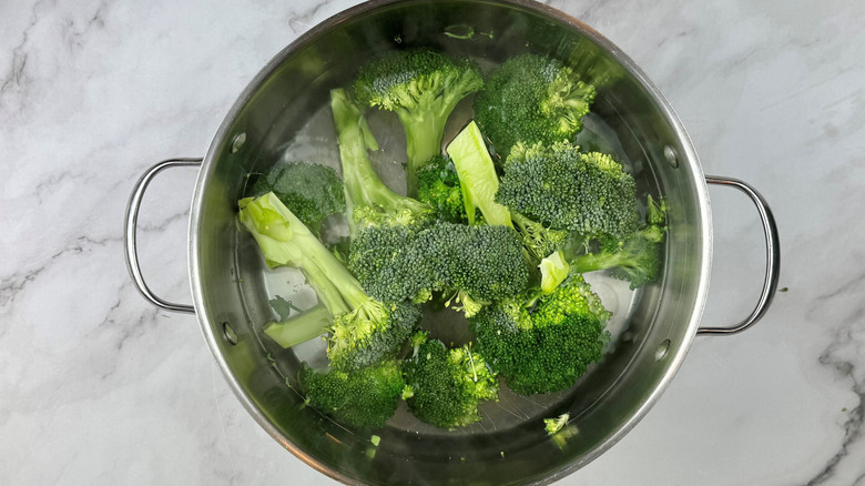 broccoli florets in pot with water