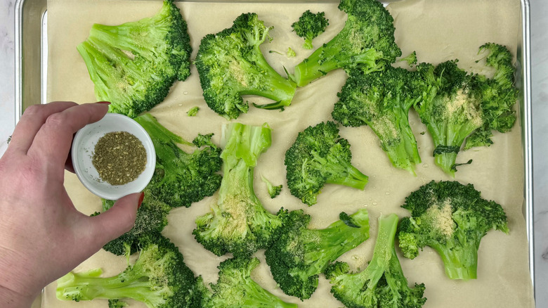 sprinkling seasoning on smashed broccoli